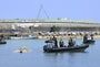 Coast Guard officers towing a small boat that capsized in the accident off Henoko - Yomiuri Shimbun