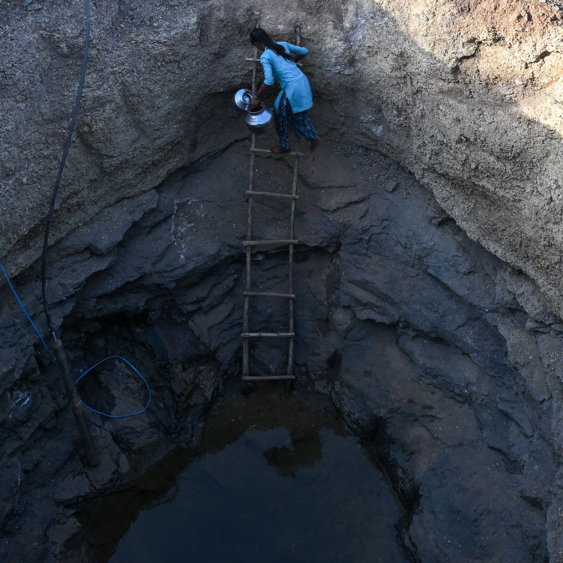 Collecting water from a well in a drought-afflicted village in Gujarat, India, in May. - nytimes.com