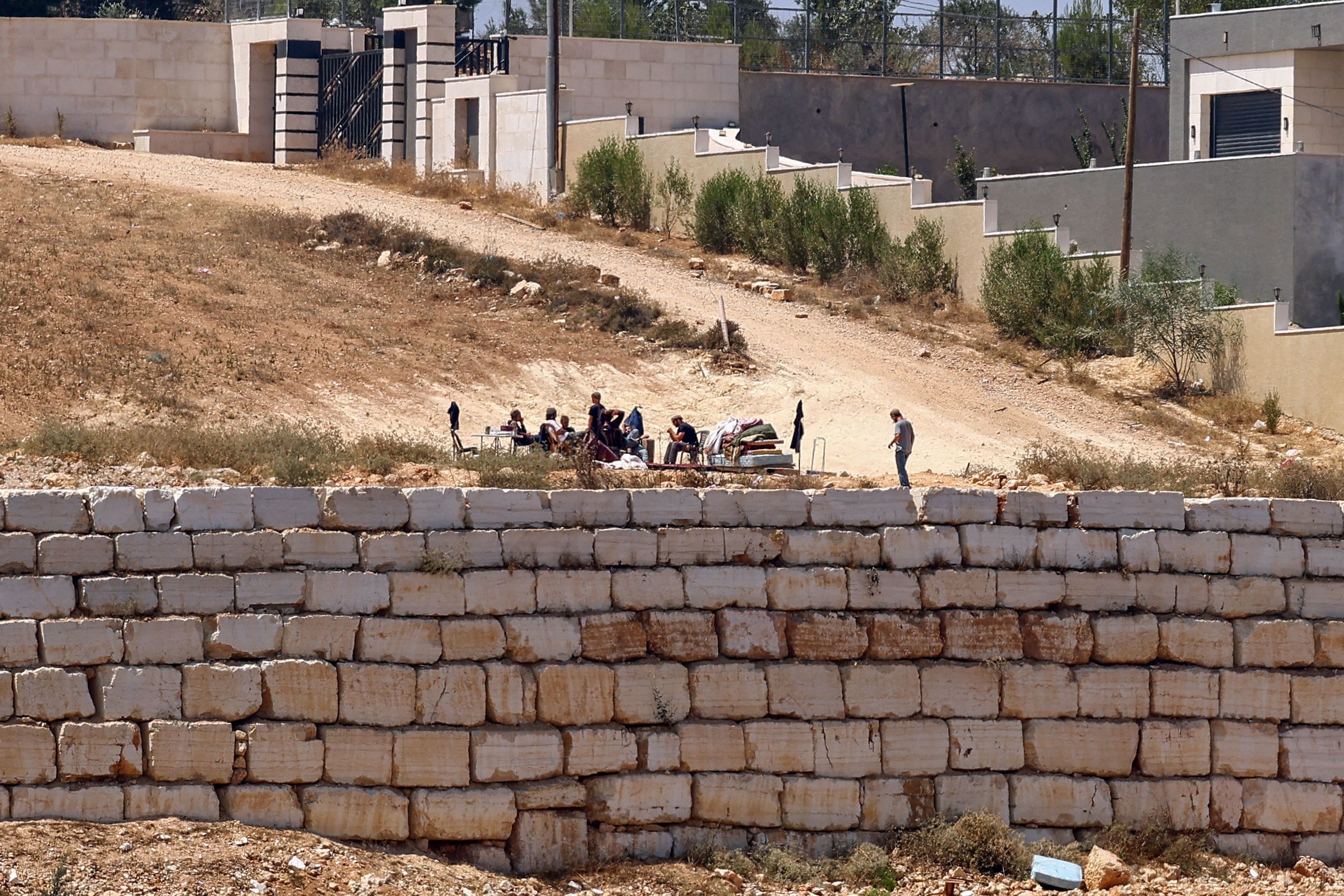 Israeli settlers gather in front of Palestinian houses in Qusra, south of Nablus. - AFP