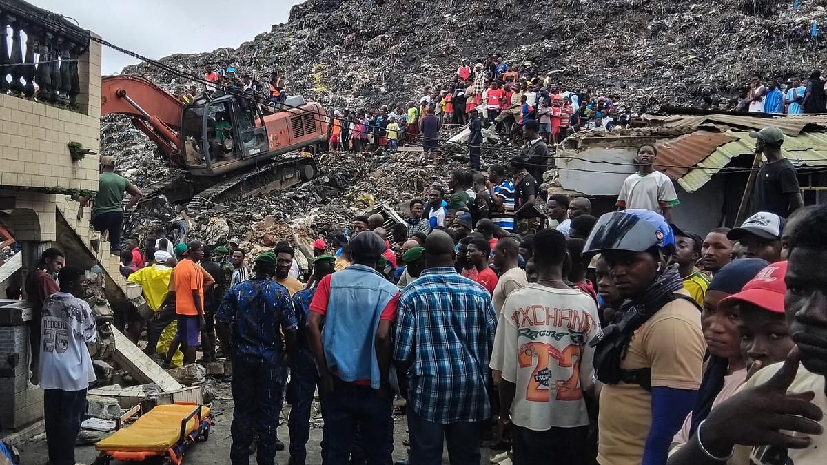 Rescue workers search through debris after the Dar Es Salam landfill collapse in Conakry. - AFP
