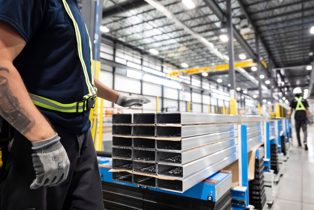 Workers prepare extruded aluminum product for packaging at Magna Aluminum Profile's fully electric powered extrusion facility in Salaberry-de-Valleyfield, Quebec, Canada, on Sept. 3, 2025. - Christopher Katsarov/The Canadian Press via AP, File