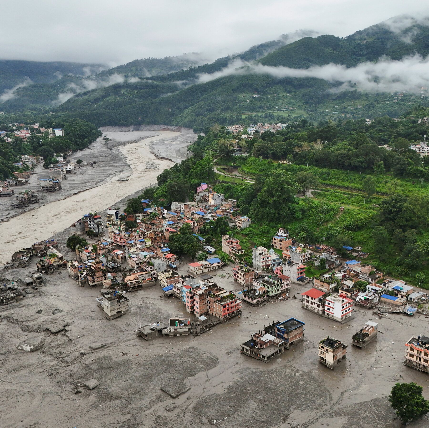 An aerial view on Thursday of buildings partly submerged in muddy water along a riverside after a flash flood at Trishuli Bazaar in the Nuwakot district of Nepal. - nytimes.com