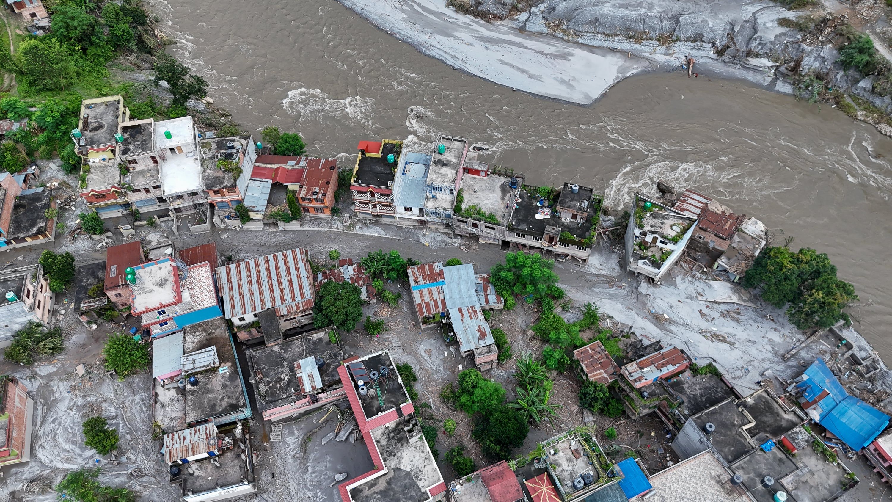Debris and mud cover an area following flash floods in Devghat, Nepal. - Getty Images