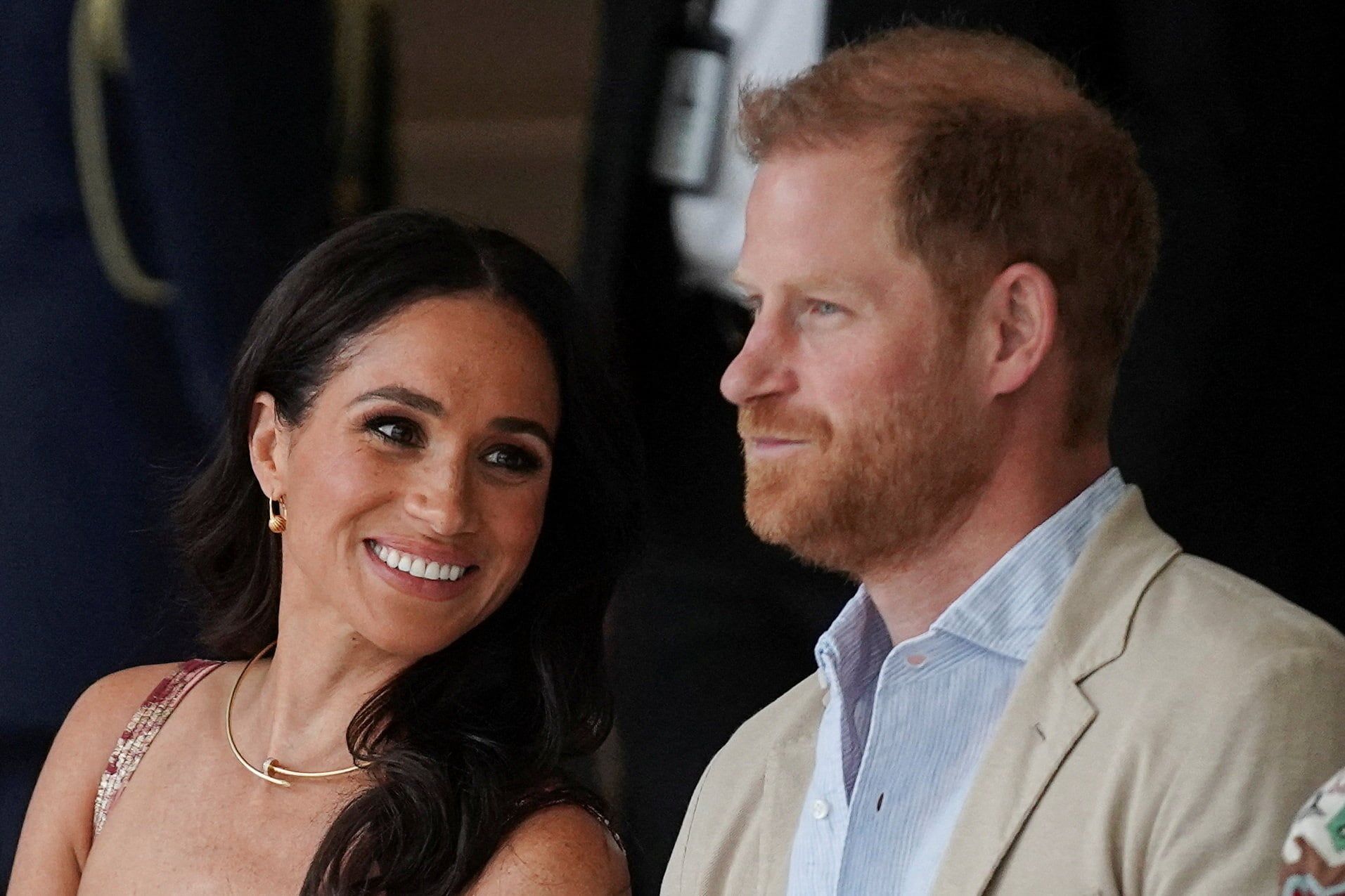 Britain's Prince Harry sits with his wife Meghan, Duchess of Sussex in August 2024; King Charles has confirmed they remain non-working royals after moving back to Britain. - theglobeandmail.com