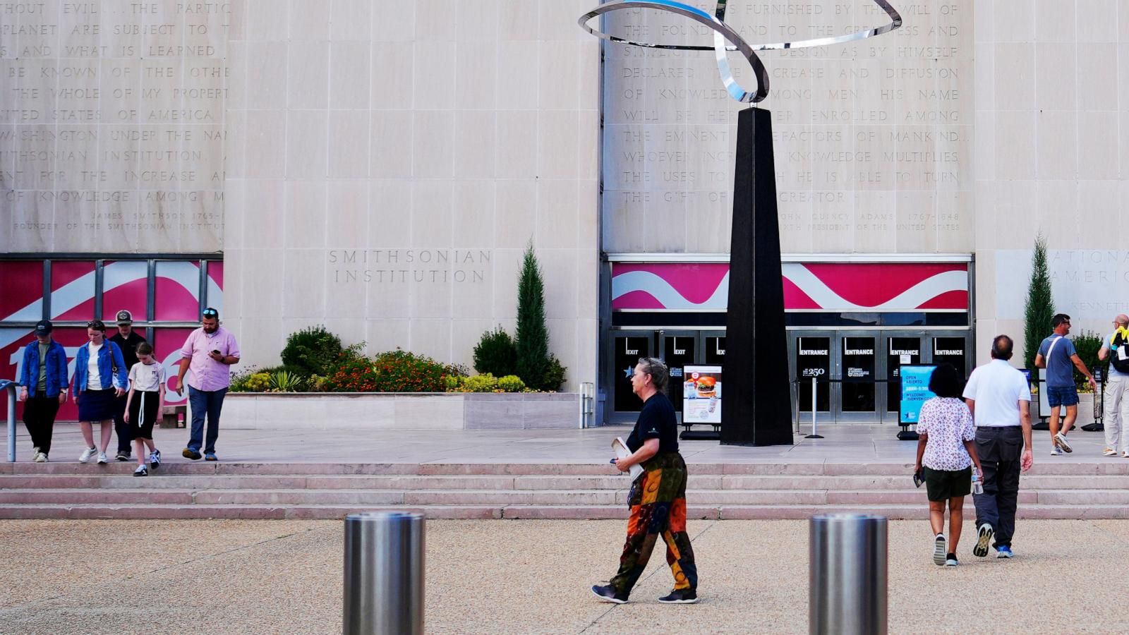 Visitors walk past the “Infinity” sculpture outside the Smithsonian National Museum of American History in Washington. - Pablo Martinez Monsivais/AP